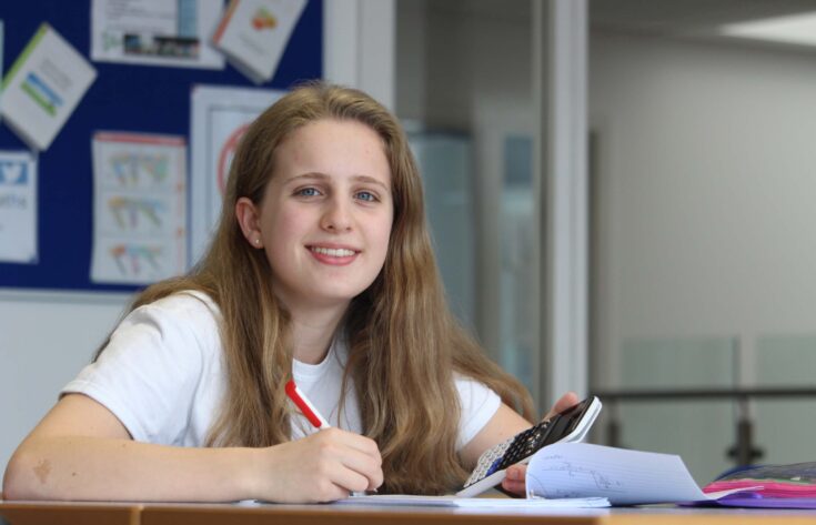 Student sitting at a desk with calculator