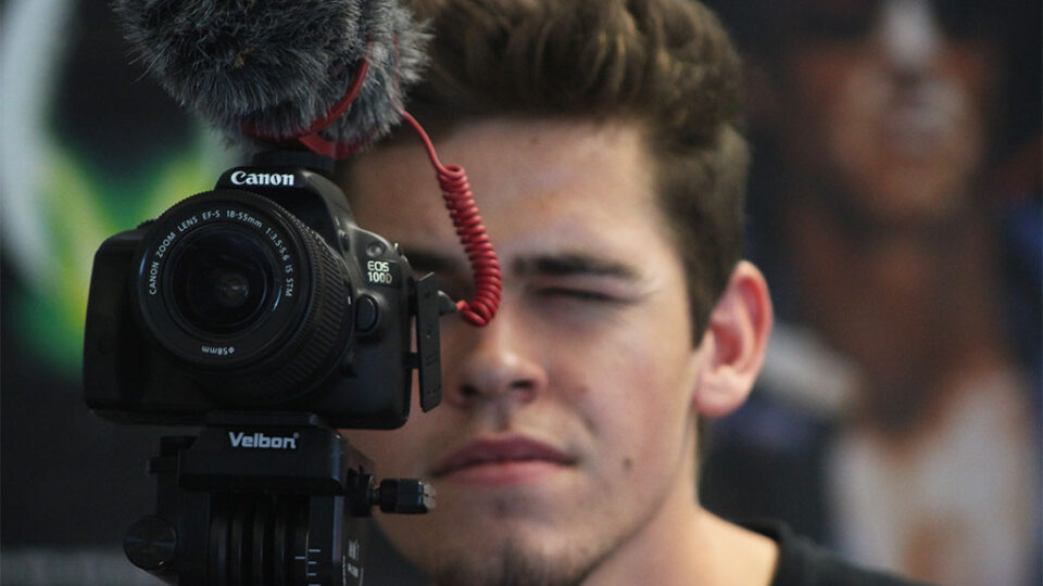 Photograph of a student looking through a camera.