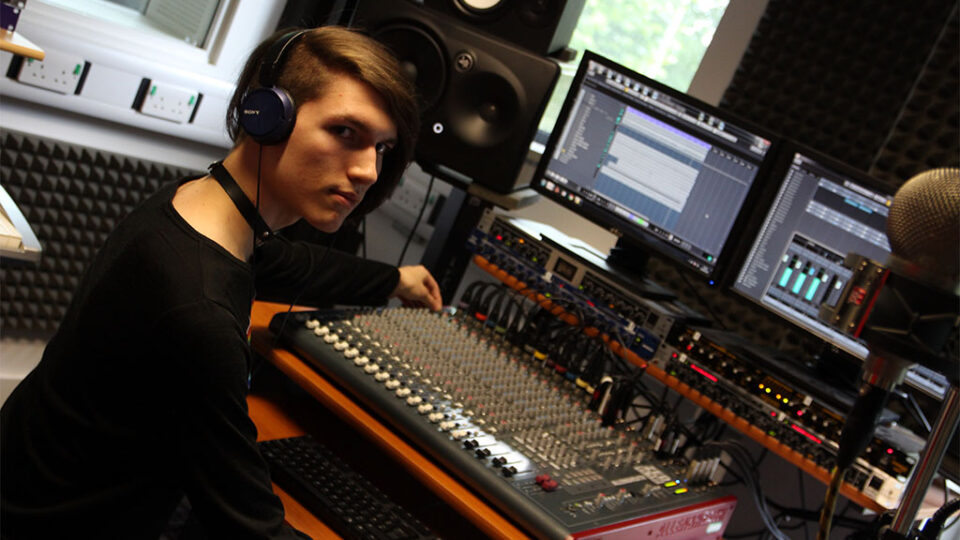 Photograph of a Music Technology student operating a mixer