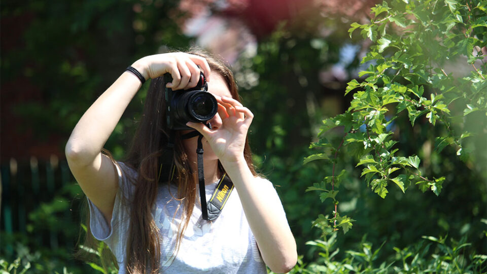 Photograph of a photography student taking a photograph outdoors.