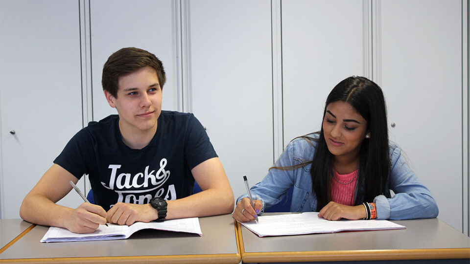 Photograph of students taking notes in a classroom.